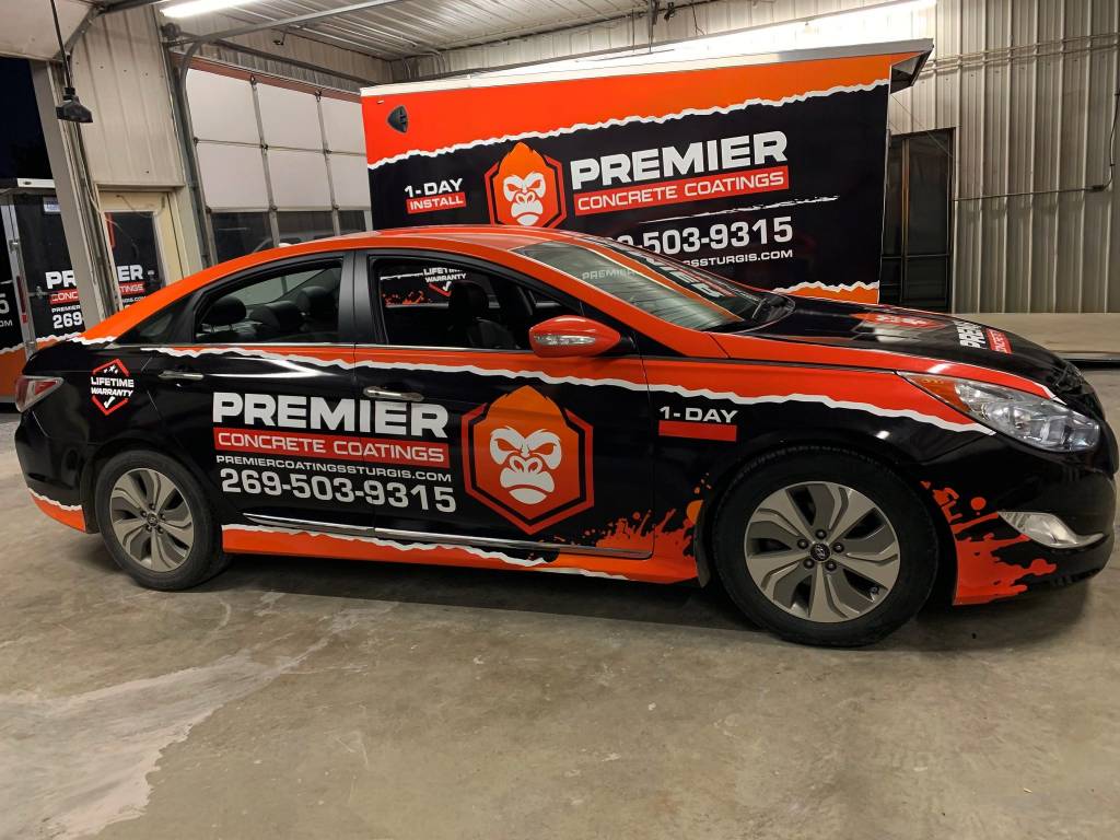 Premier Concrete Coatings sedan full wrap in black and orange — Design It Wraps commercial vehicle branding